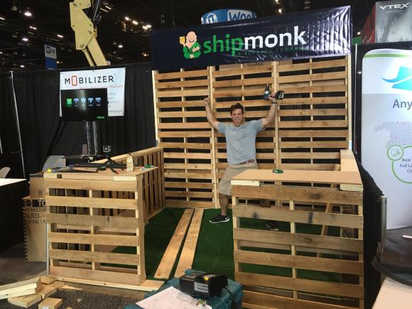 Kevin celebrates as ShipMonk's trade show booth nears completion.