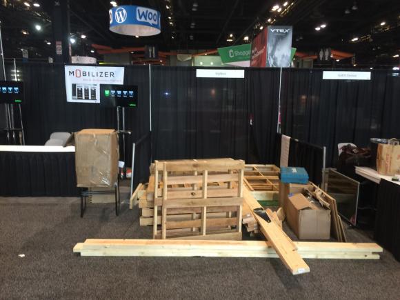 A pallet and strips of wood serve as the main materials of ShipMonk's trade show booth.