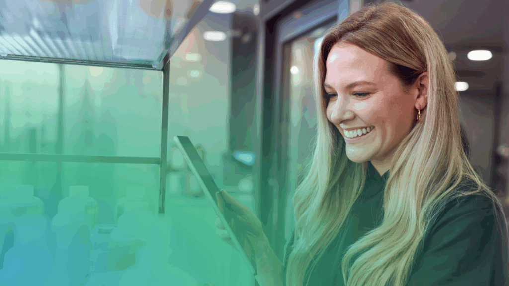 A cheerful woman with long blonde hair checks her tablet by neatly arranged bottles, making ShipMonk.com’s efficiency look easy. via ShipMonk.com