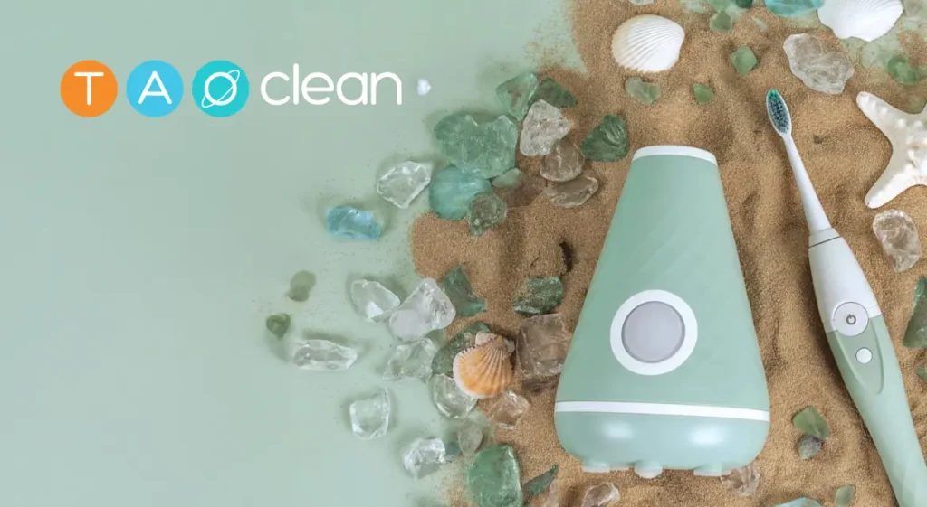 A mint green toothbrush and holder rest on sandy seashells and sea glass, TAO clean nearby—much like ShipMonk: delightfully organized. via ShipMonk.com