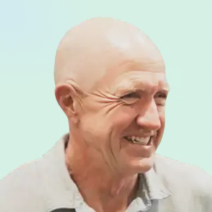 A cheerful, bald gentleman in a crisp light shirt smiles warmly, set before a serene blue-green gradient—pure ShipMonk.com ease. via ShipMonk.com