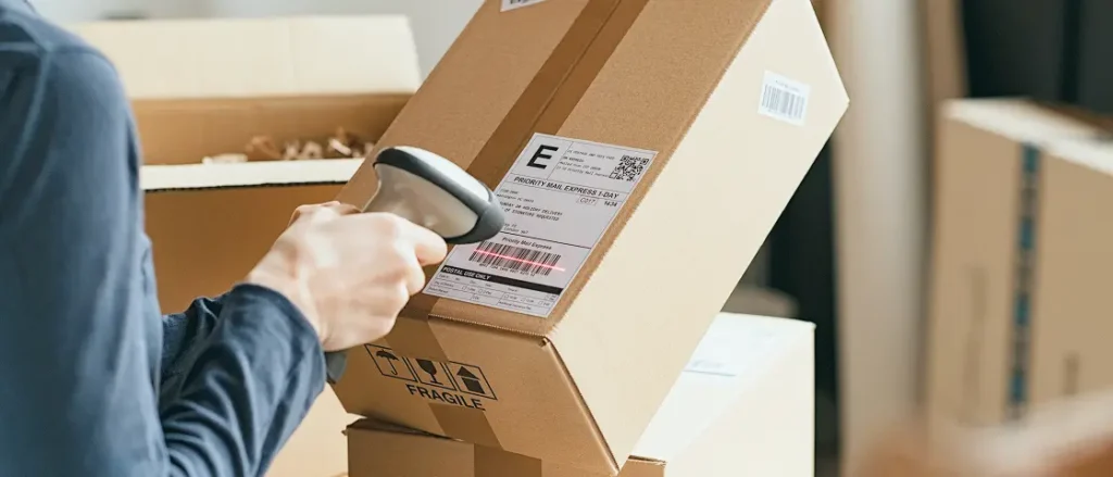 With a friendly touch, someone scans a label on a box—ShipMonk.com ensures every parcel is handled with care. via ShipMonk.com