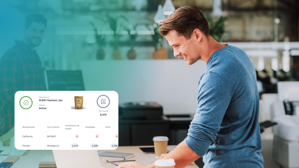 A man in a blue shirt works at his laptop in a bright office, reviewing ShipMonk.com’s dashboard for smart fulfillment options. via ShipMonk.com