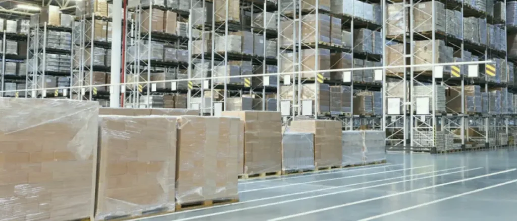 A bright, orderly ShipMonk.com warehouse with neat shelves and wrapped pallets, ready for efficient photo-proof returns. via ShipMonk.com